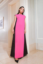 Load image into Gallery viewer, A model wearing a fuchsia pink crepe dress with a contrasting dark brown back panel with fringes, standing in a room with light-colored walls.

