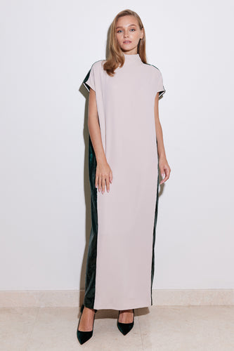 A model wearing a straight cut nude dress with a contrasting green lamé back panel, cap sleeves, high neck collar, and two back buttons.