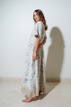 Load image into Gallery viewer, A woman wearing a textured grey and cream jacquard dress with palm leaves pattern, half sleeves, side pockets, and a cream fringed rope tassel edge.
